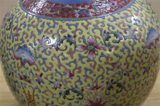 A Canton enamelled bottle vase, decorated flowers, foliate scrolls and Chinese characters on a yellow ground, height 40cm, faults